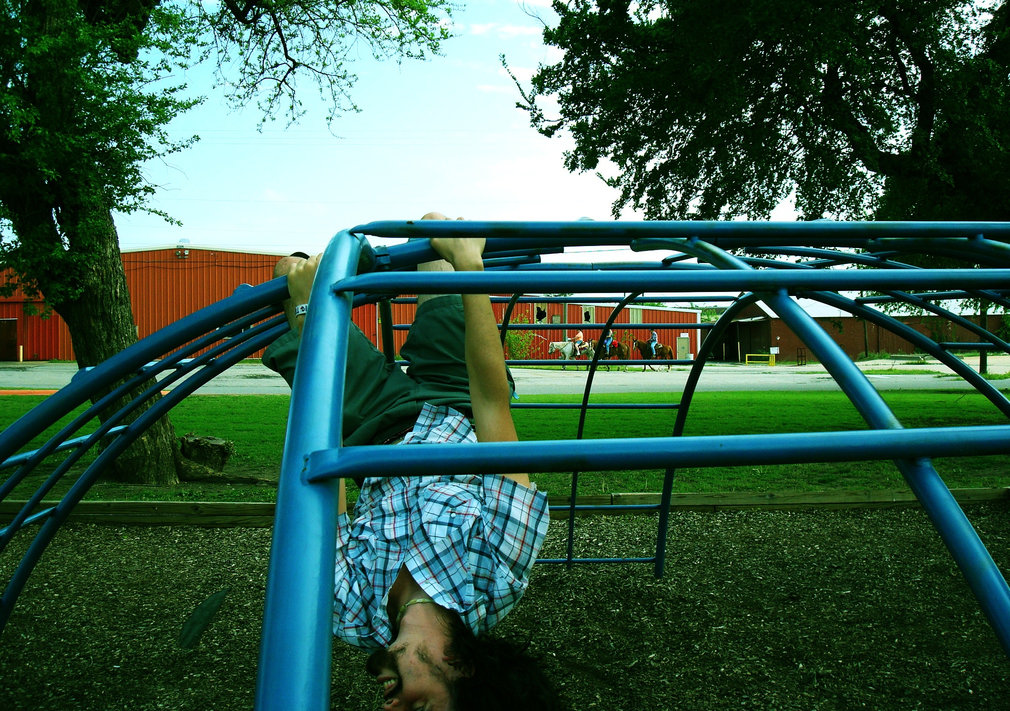 Daniel being Daniel, hanging upside-down from monkey bars